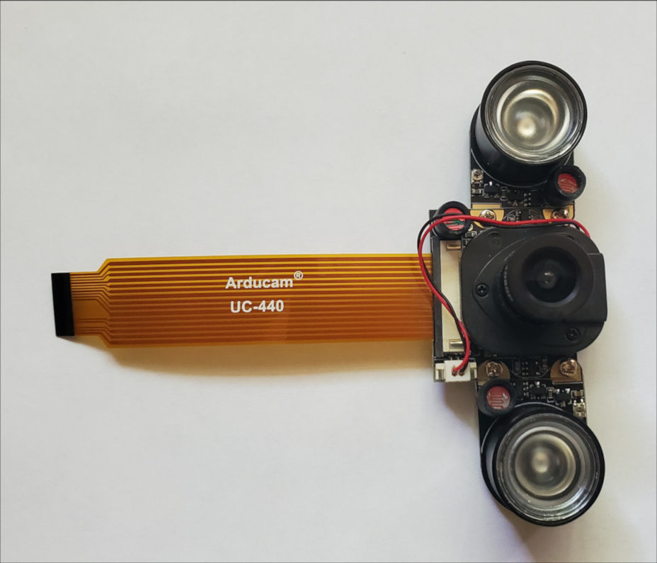 Infrared camera module with IR LED's and orange ribbon cable attached.